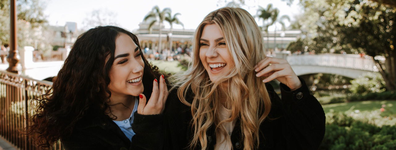 Blondes und schwarzhaariges Mädchen am Lachen 