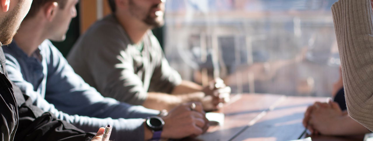 Menschen sitzen an Tisch und Licht fällt durch Scheibe