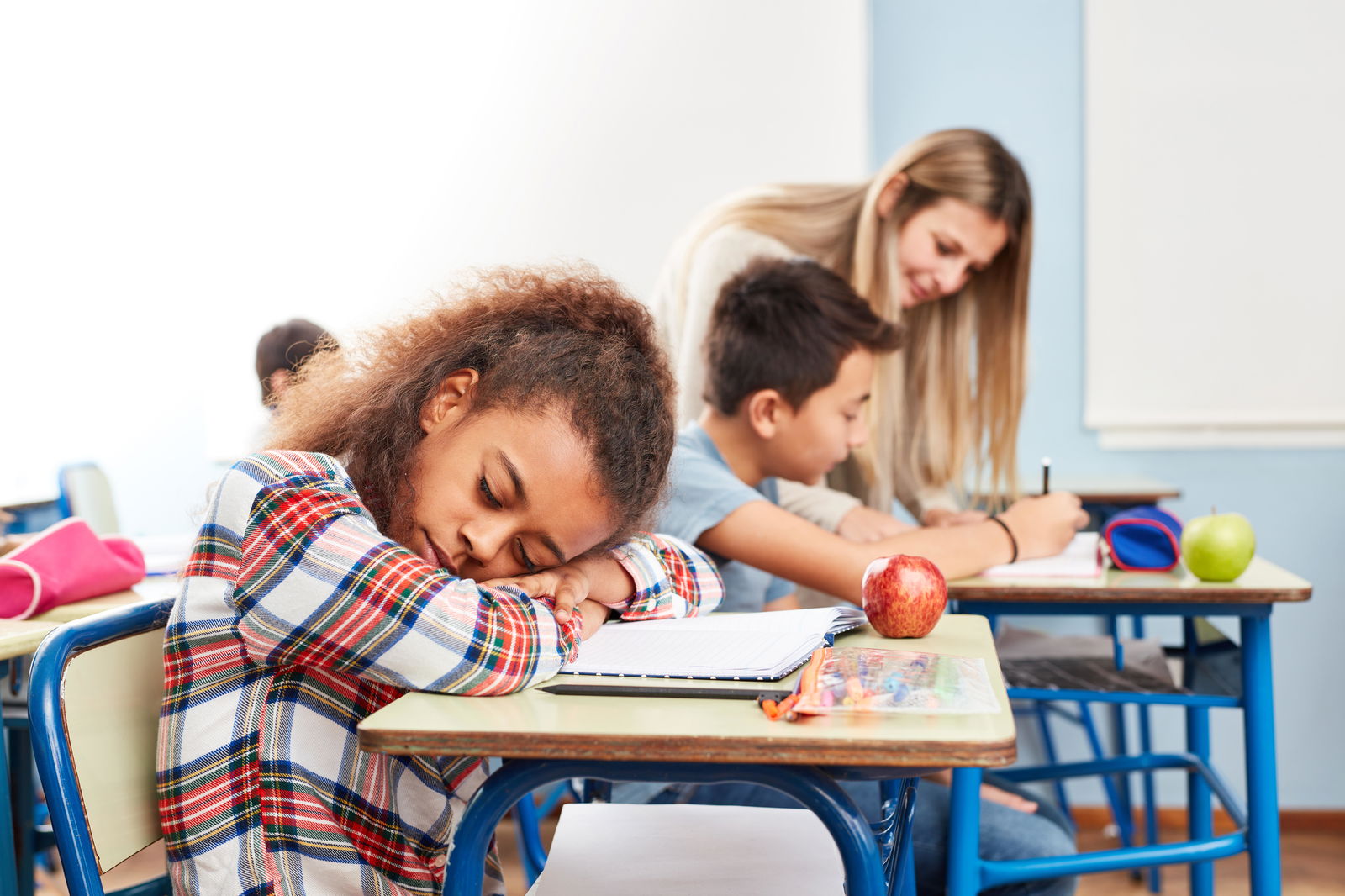 Schülerin schläft in der Schule auf Tisch