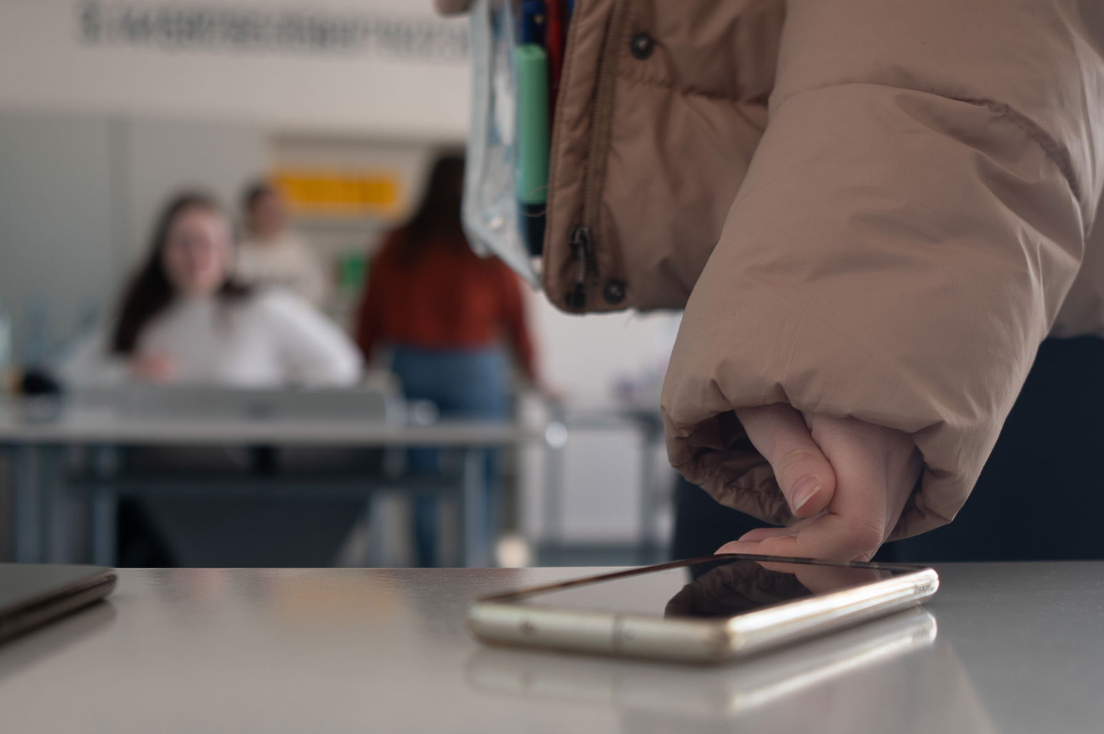 Schülerin legt Handy im Klassensaal auf den Tisch