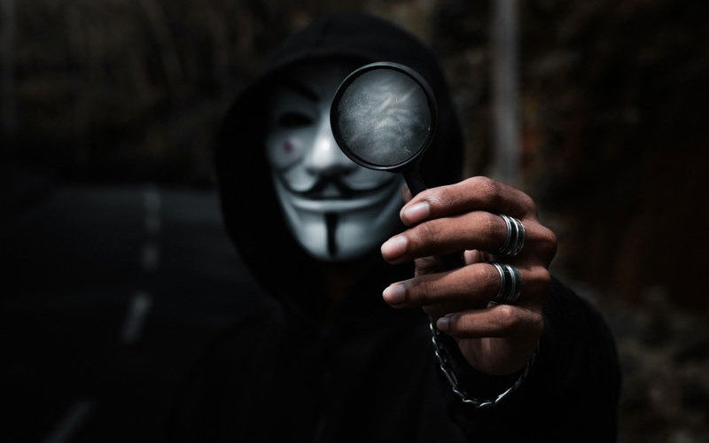 Mann mit Maske und Lupe