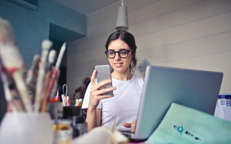 Frau mit Handy und Laptop 