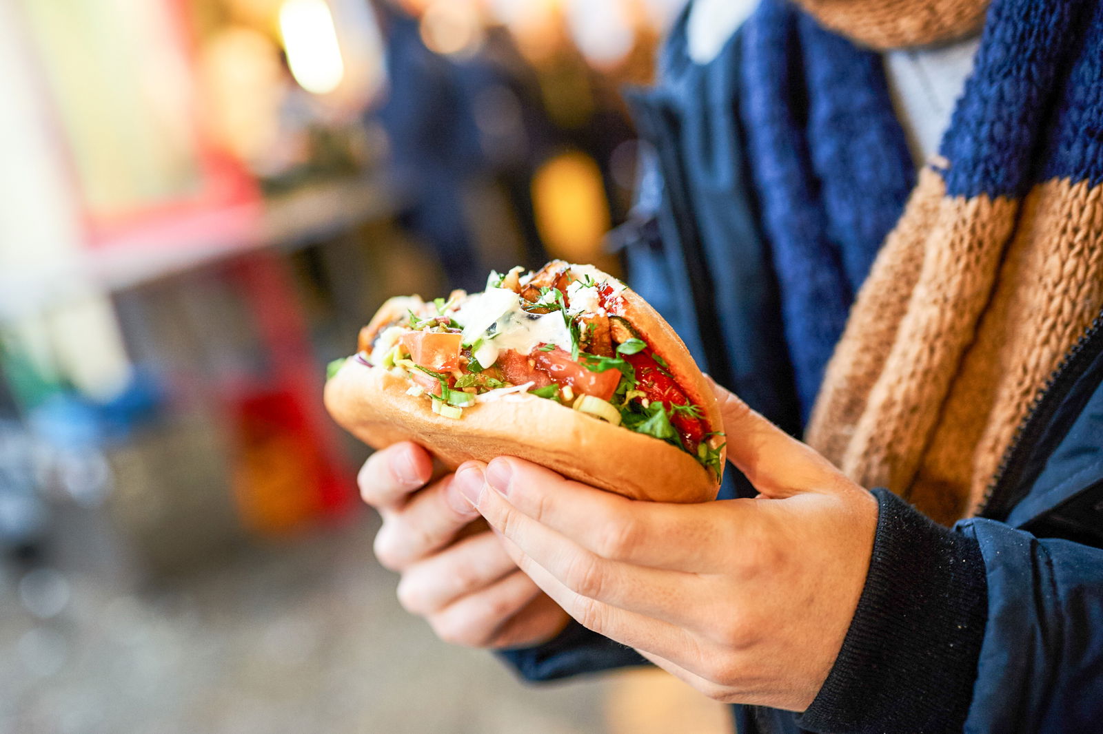 Ein Mann hält einen Döner in den Händen 