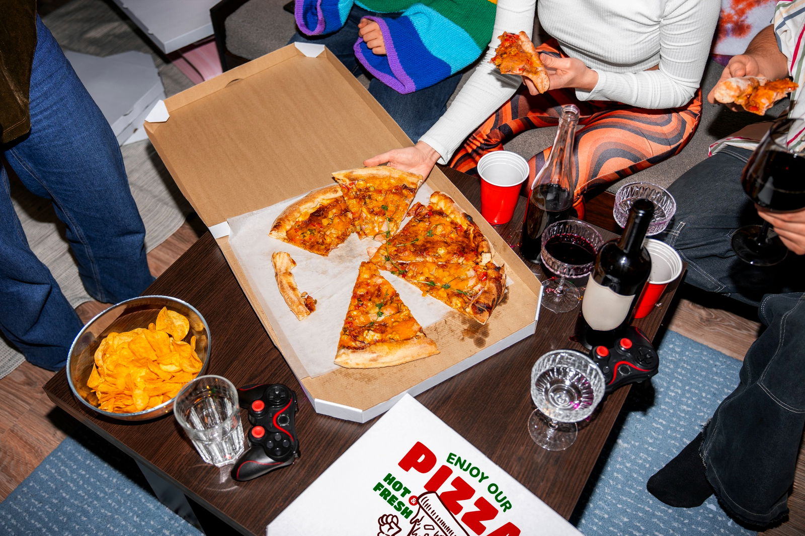 Eine Gruppe junger Menschen teilt sich eine Pizza während einer Party