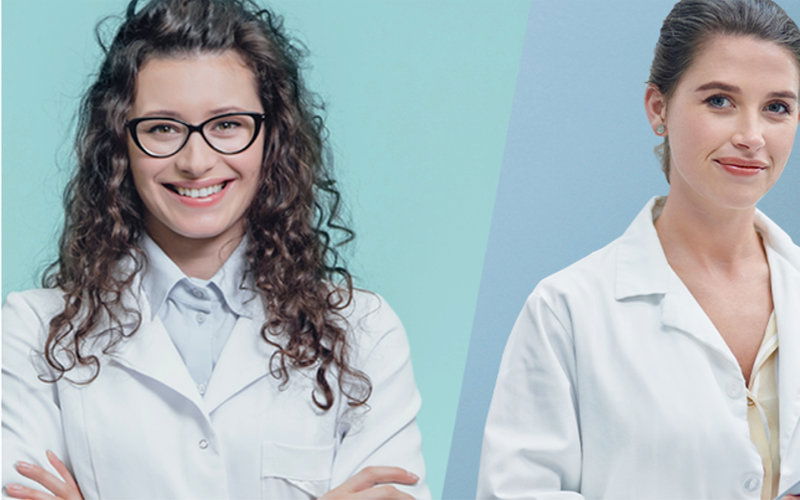 Ärztin mit Brille und andere Ärztin lächelnd 