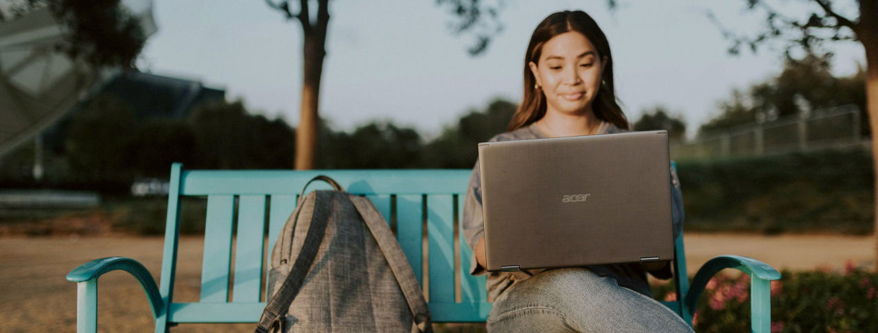 Frau mit Laptop auf einer Bank