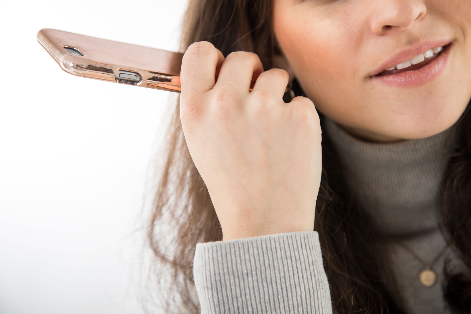 Eine junge Frau hört eine Sprachnachricht auf ihrem Handy an 