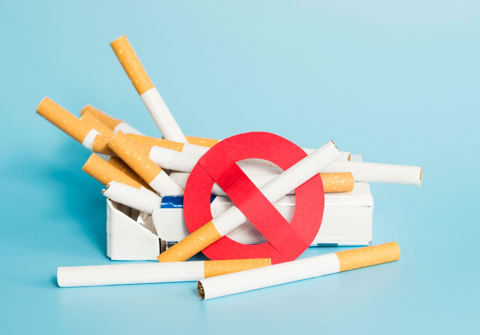 Eine Schachtel Zigaretten mitsamt eines Verbotsschildes 