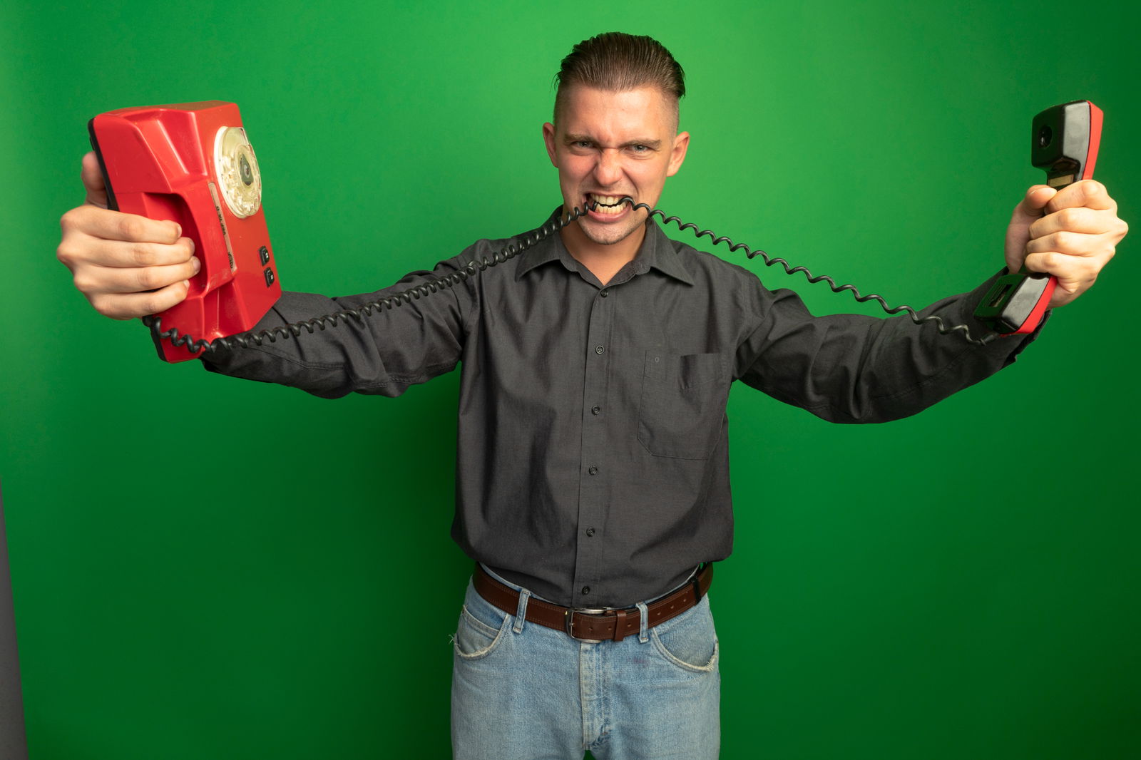 Ein Mann beißt wütend in das Kabel seines Telefons