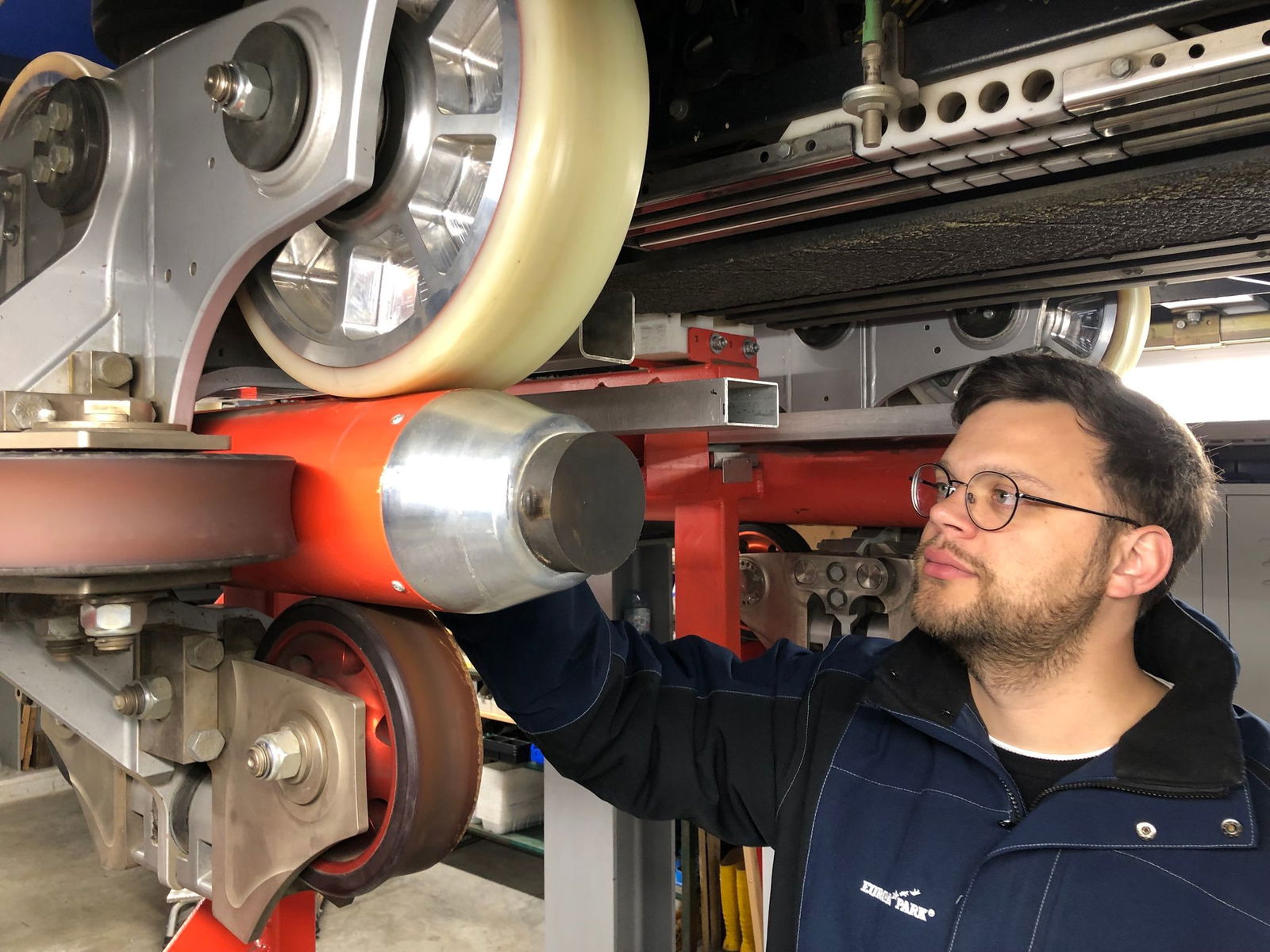 Ein leitender Mitarbeiter des Europa-Parks begutachtet Räder eines Achterbahnzugs. 