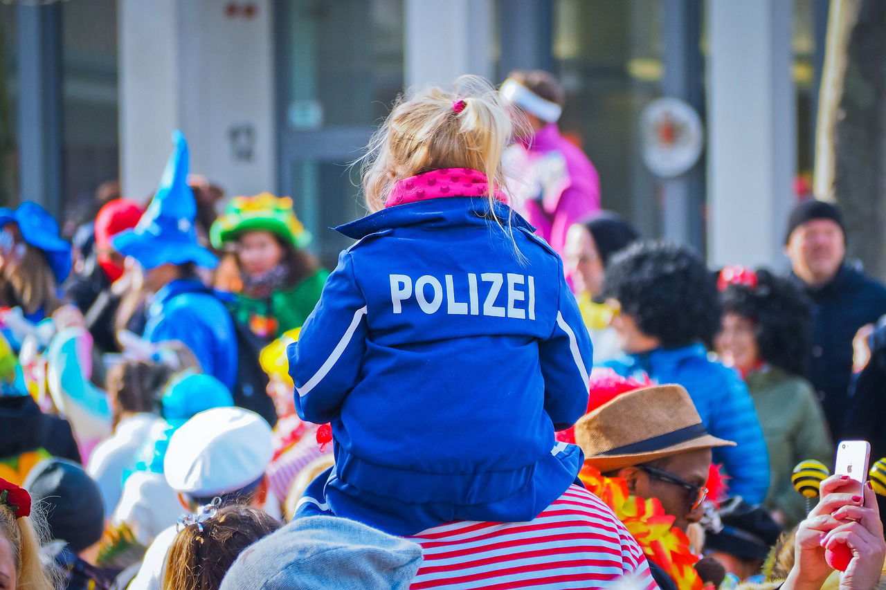 Kind mit Polizeikostüm auf Straßenfastnacht