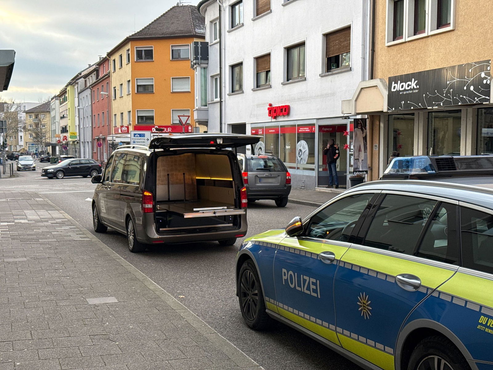 Ein Leichenwagen parkt vor dem Haus in der Innenstadt von Bruchsal. Vor wenigen Stunden spielte sich hier ein tödlicher Polizeieinsatz ab.
