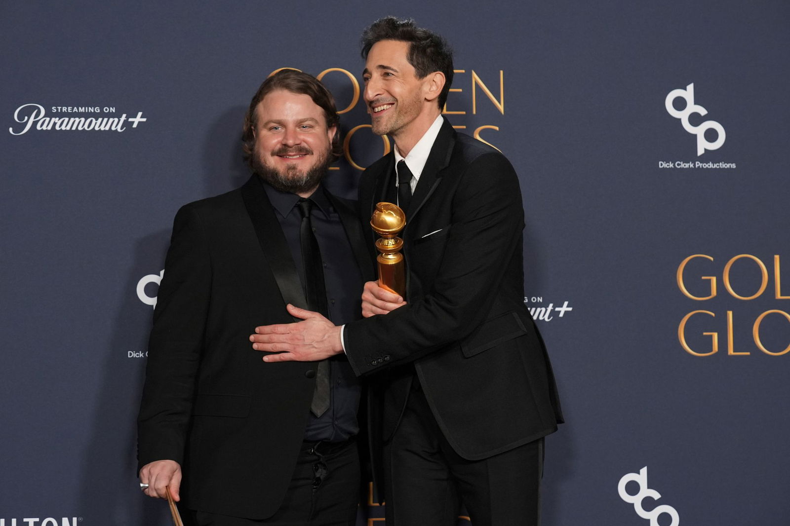 Brady Corbet und Adrien Brody posieren bei den Globes mit ihren Preisen. 