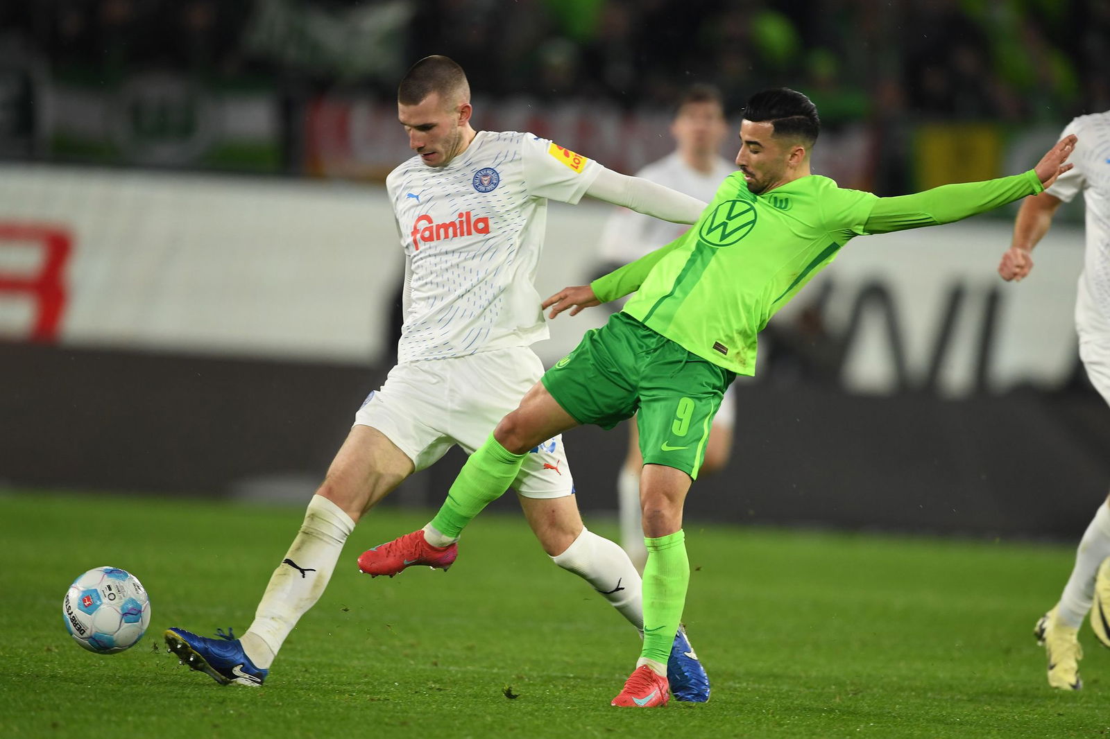 Wolfsburgs Mohamed Amoura (r) spielt gegen Kiels David Zec.