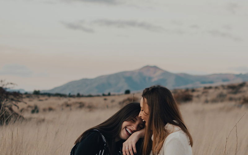 Zwei lachende Mädchen, Berg im Hintergrund 