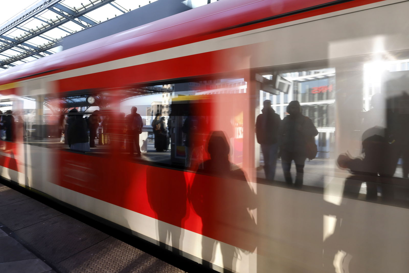 Menschen am Bahnsteig spiegeln sich in S-Bahn