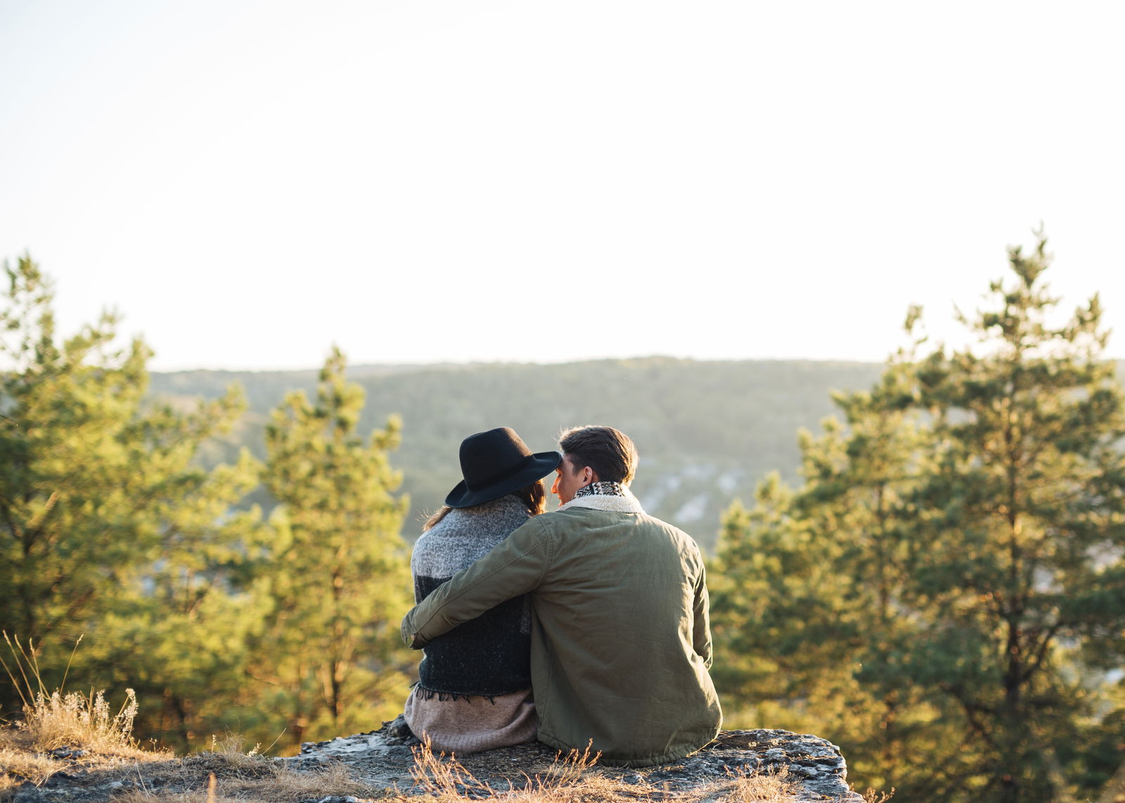 Paar sitzt auf Felsen und schaut in den Wald