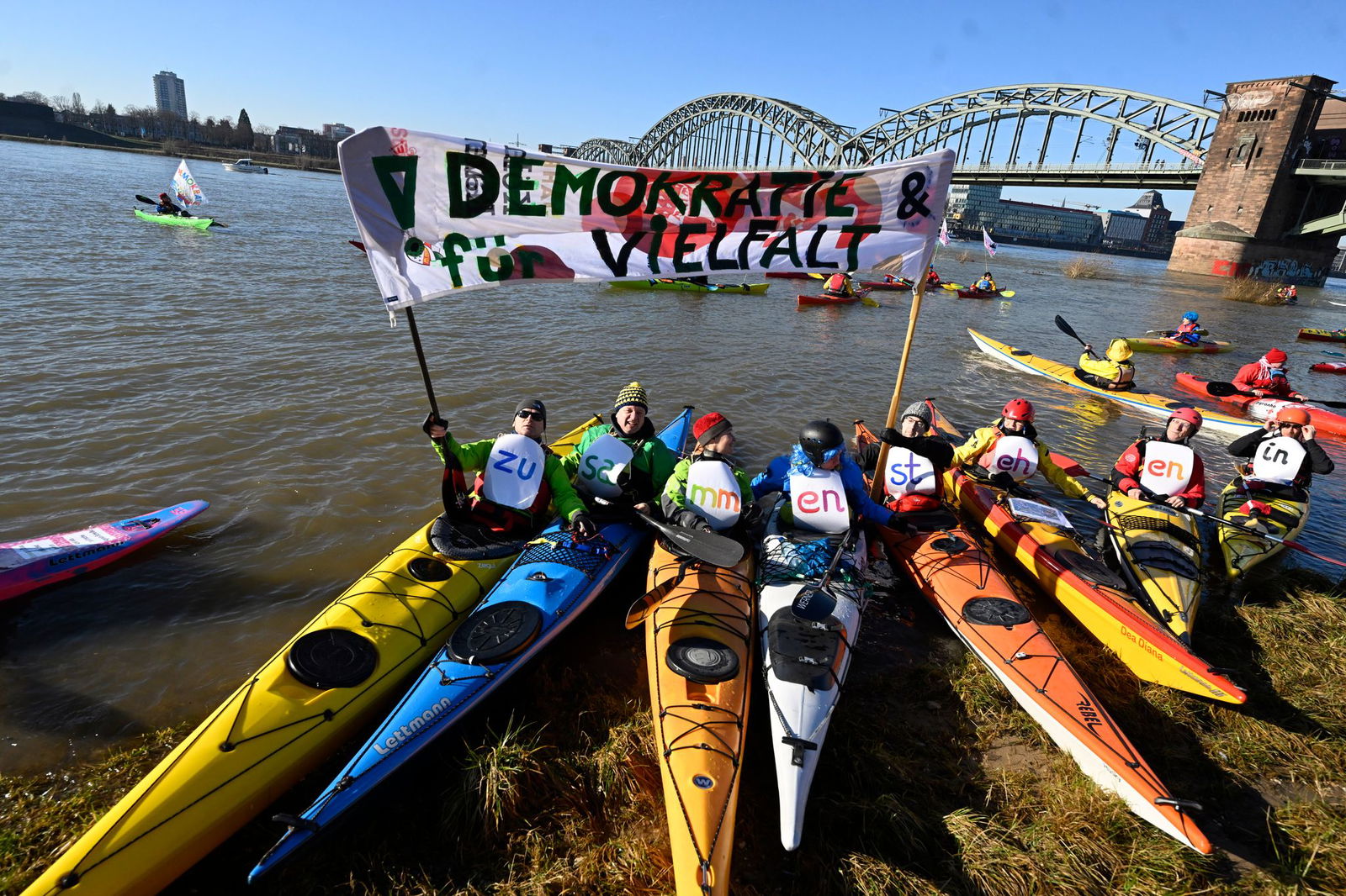 In Köln demonstrieren Wassersportler auf dem Rhein.