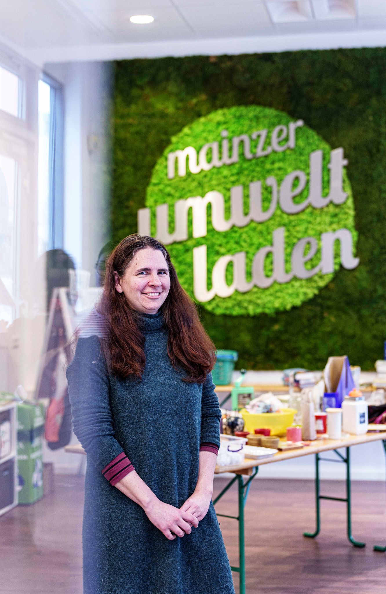 Die Leiterin des Mainzer Umweltladens, Cordula Zimper, steht vor einem der Tische des Warentauschmarkts.