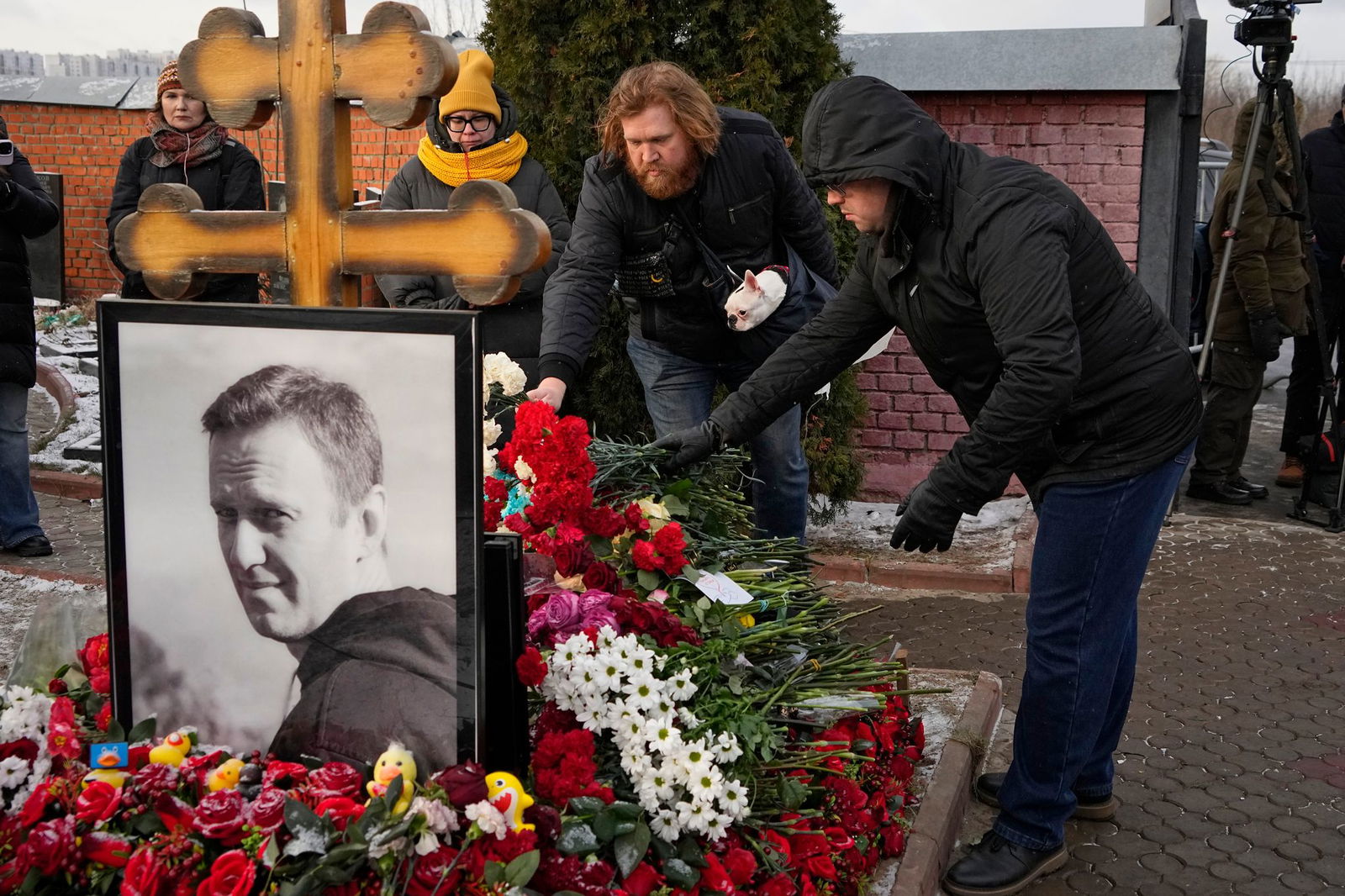 Menschen legen ein Jahr nach dem Tod des russischen Oppositionsführers Alexej Nawalny auf dem Borisowskoje-Friedhof in Moskau Blumen an seinem Grab nieder. 