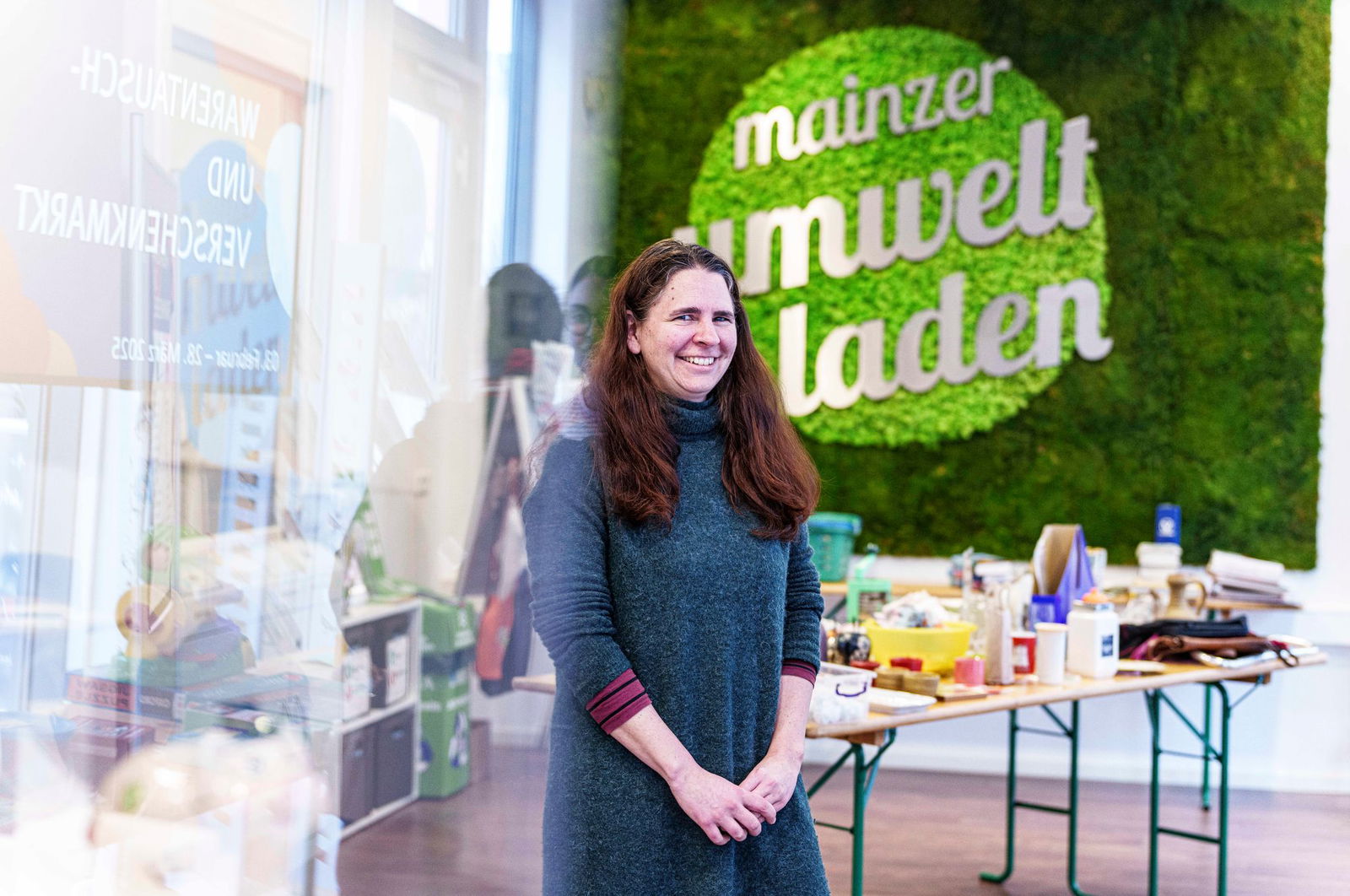Die Leiterin des Mainzer Umweltladens, Cordula Zimper, steht vor einem der Tische des Warentauschmarkts.