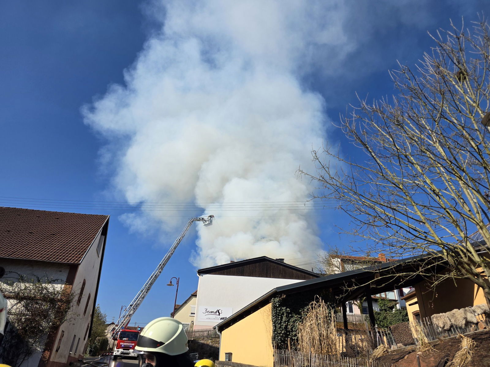 Feuerwehrleute löschen einen Brand in einer Schreinerei in Nanzdietschweiler (Landkreis Kusel).