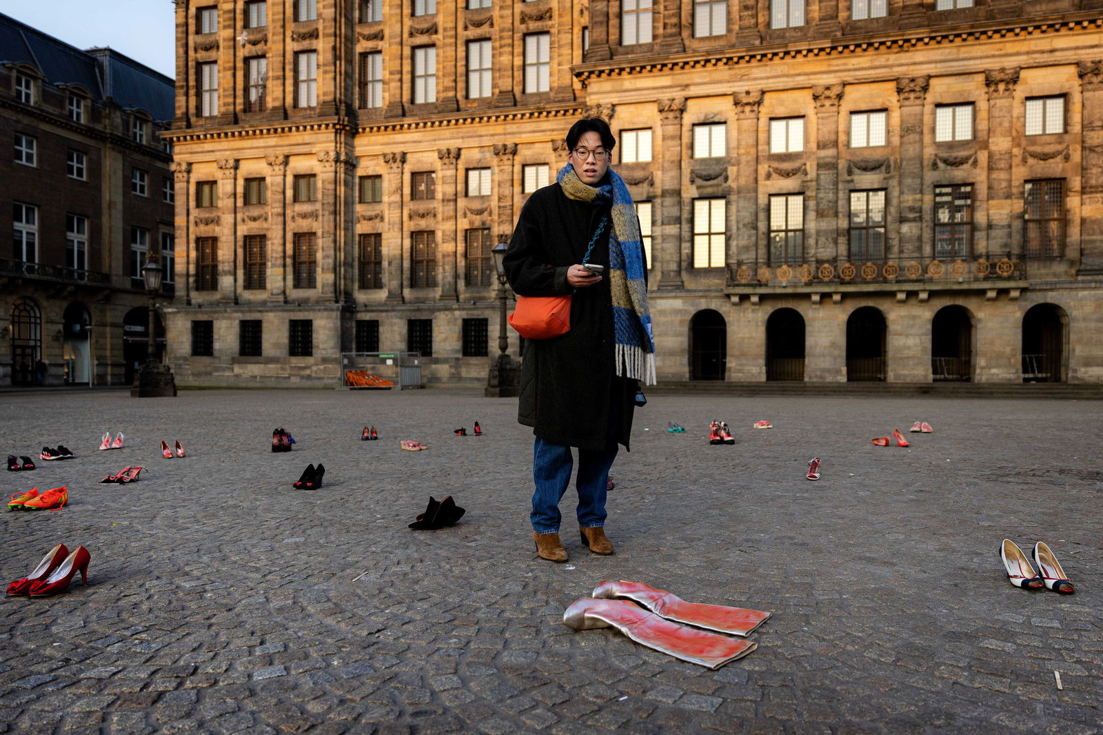  44 Paar rote Absätze auf dem Dam-Platz in Amsterdam. Am Internationalen Frauentag machen die Schuhe auf ermordete Frauen aufmerksam, die Opfer häuslicher Gewalt oder Rachemorde geworden sind.
