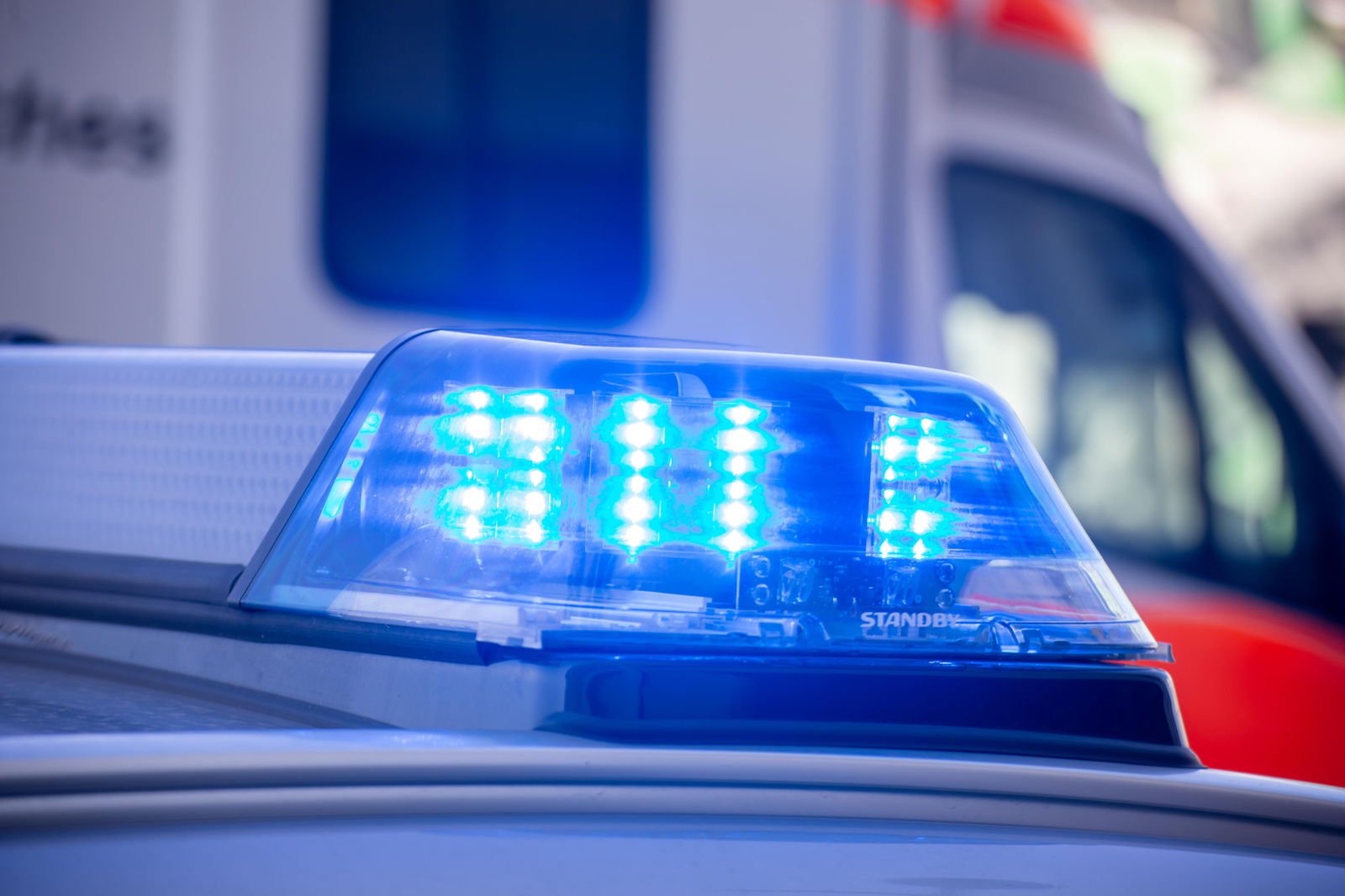 Blaulicht eines Streifenwagens und Rettungswagen im Hintergrund