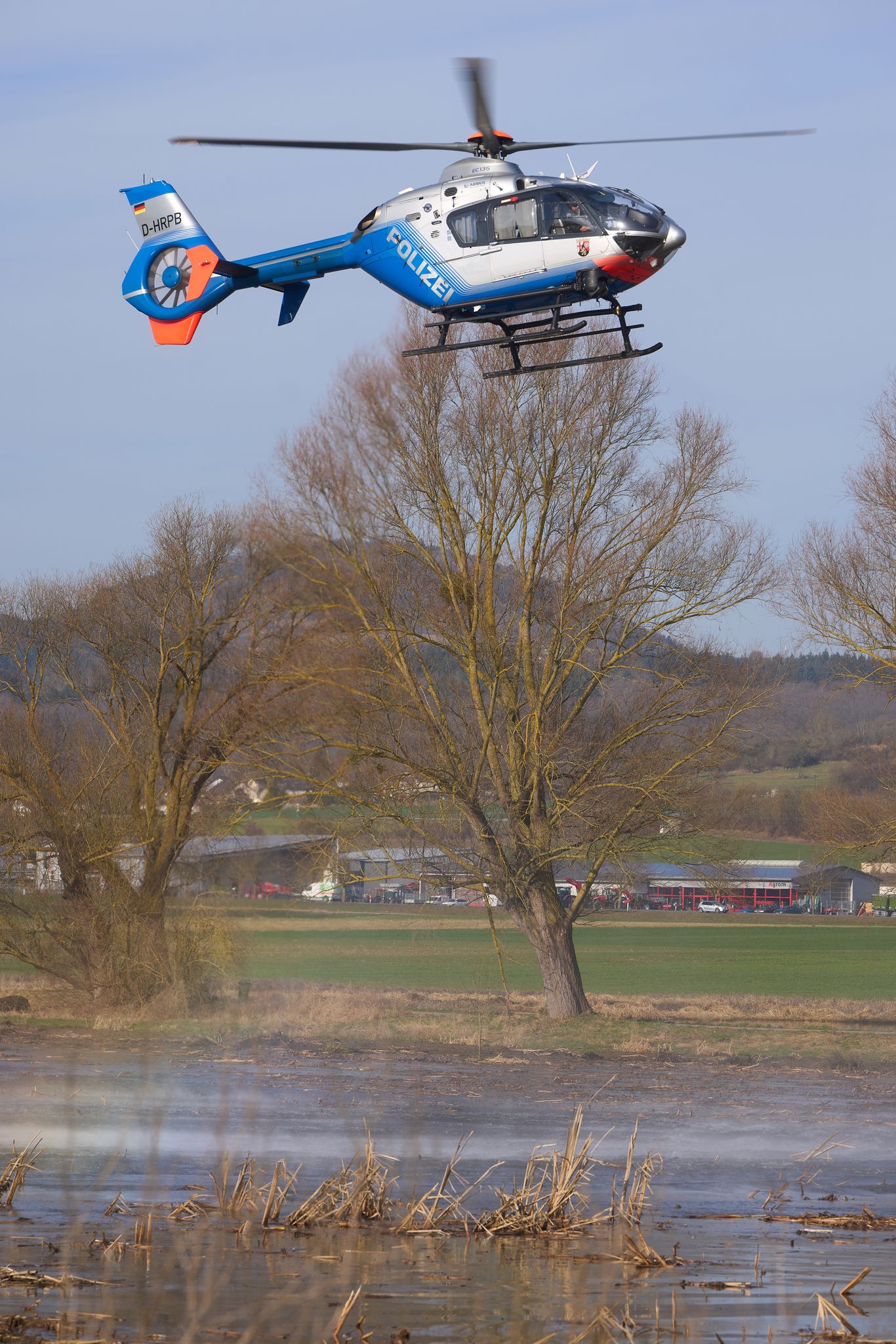 Ein Polizeihubschrauber hilft mit seinem Staustrahl, das Naturschutzgebiet „Thürer Wiesen“ zu reinigen.