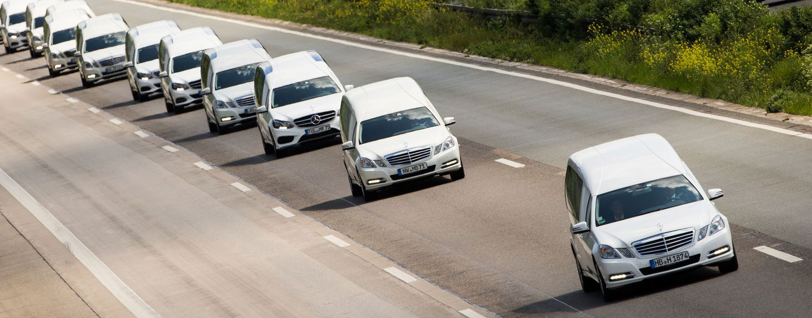 In einem Konvoi aus 16 weißen Leichenwagen werden die Schülerinnen und Schüler drei Monate nach dem Absturz wieder in ihre Heimat nach Haltern gebracht. (Archivbild)