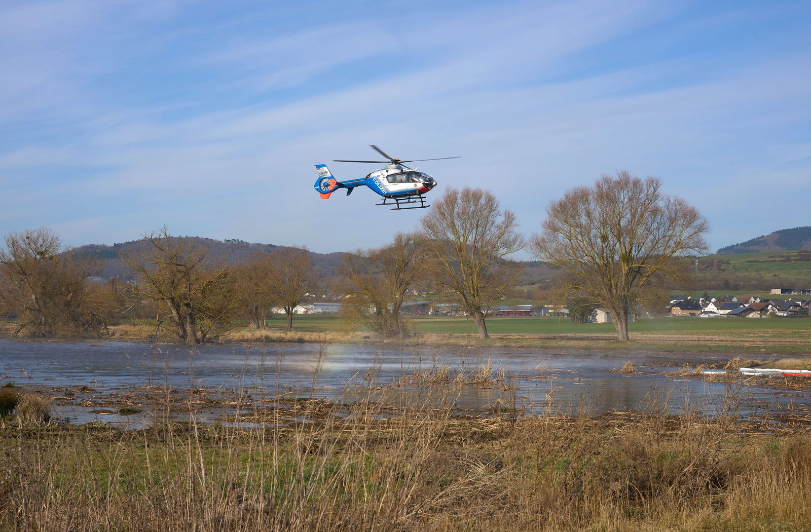 Ein Polizeihubschrauber hilft mit seinem Staustrahl, das Naturschutzgebiet zu reinigen.