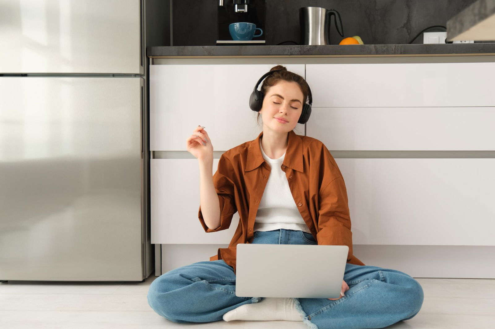 Eine Frau hört Musik und arbeitet am Laptop