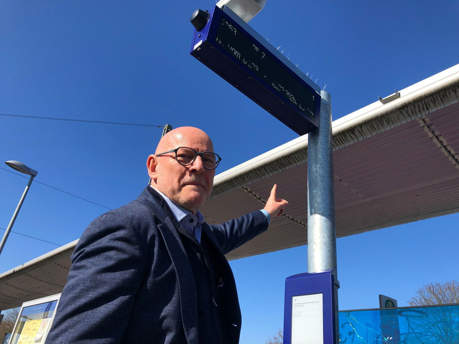 Baden-Württembergs Verkehrsminister Winfried Hermann (Grüne) steht vor einer neuen Anzeigetafel am Bahnhof in Emmendingen.