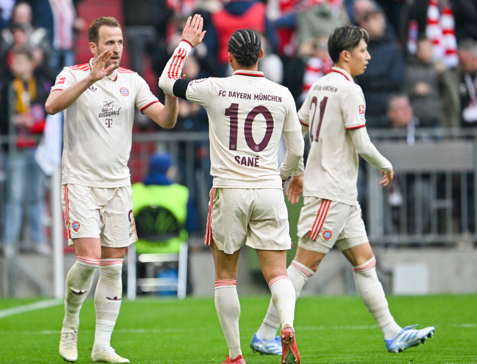 Torschützen unter sich: Harry Kane (l) und Leroy Sané (m). Hiroki Ito (r) war da noch auf dem Platz.
