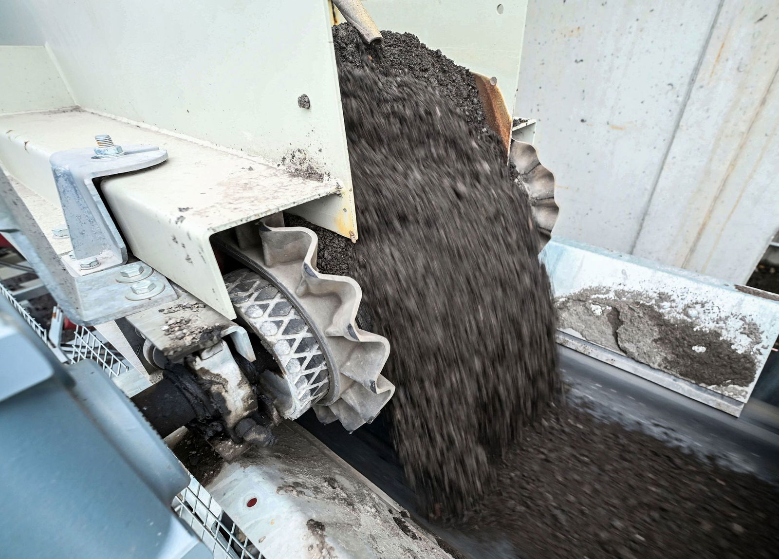 Über Förderbänder werden die Zutaten nach einer bestimmten Asphalt-Rezeptur zusammengeführt.