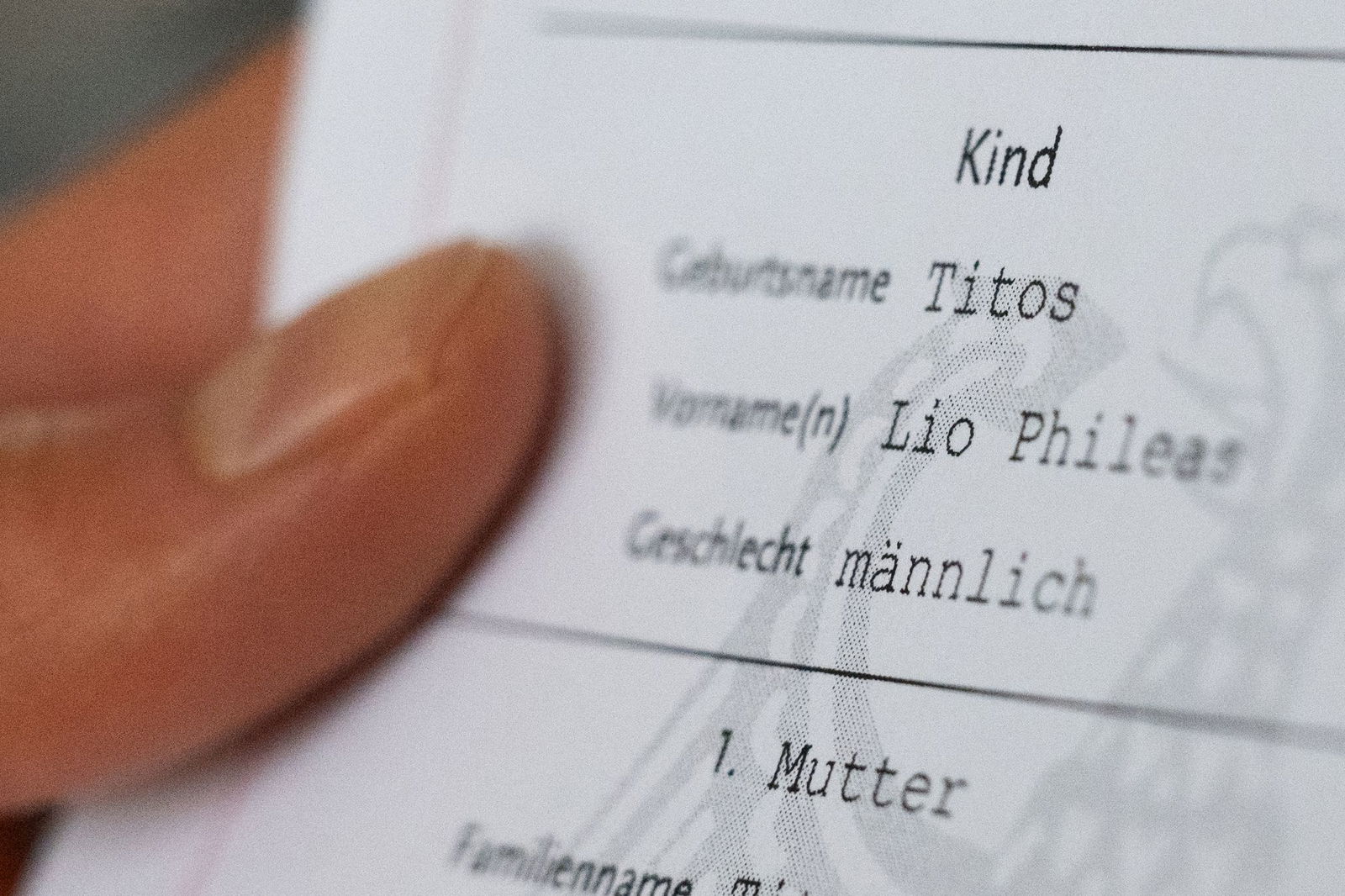 Lio Titos hält seine Geburtsurkunde in der Hand.
