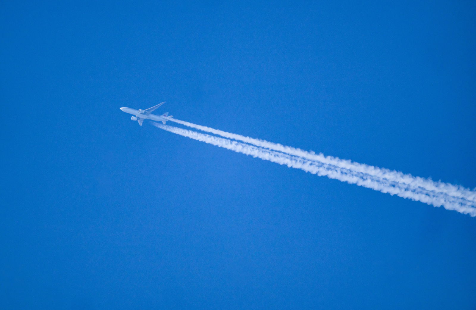 Flugzeug hinterlässt Kondensstreifen am blauen Himmel