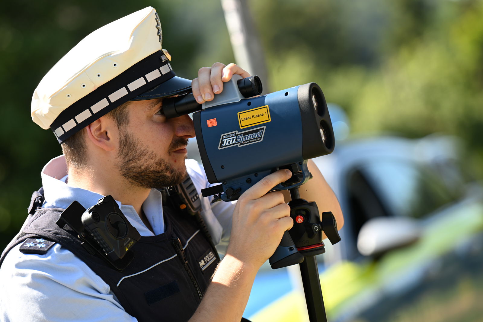 Polizist mit Laserhandmessgerät