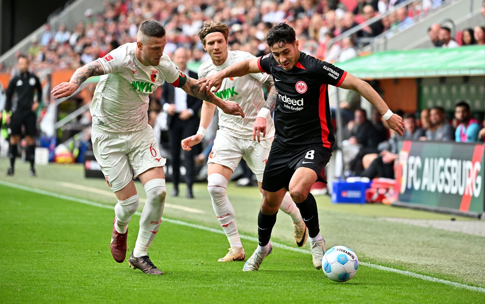Viel Kampf in Augsburg: Frankfurts Farès Chaïbi (r) gegen FCA-Kapitän Jeffrey Gouweleeuw (l) und Kristijan Jakic.