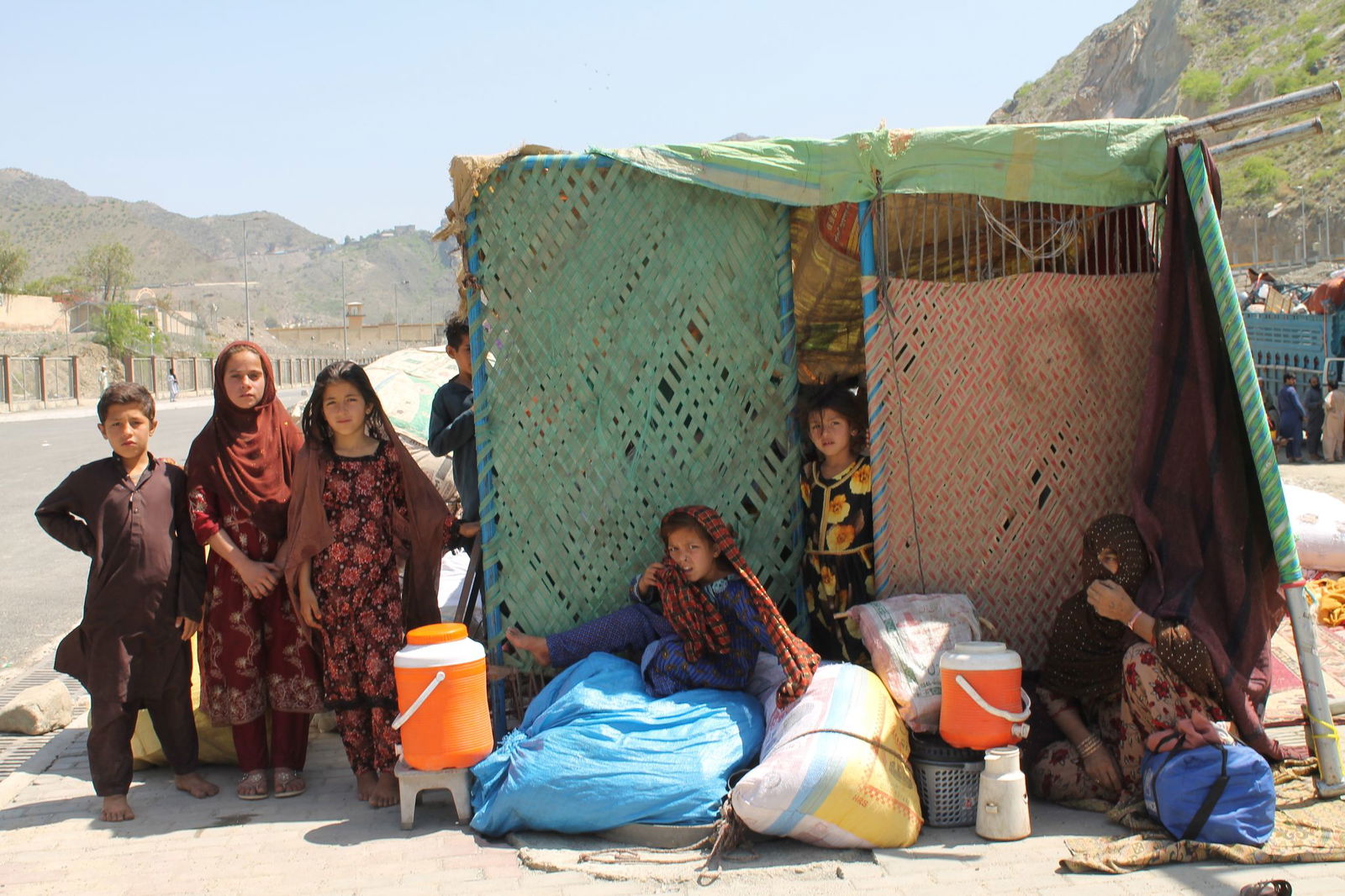 Afghanische Flüchtlinge sitzen mit ihren Habseligkeiten am Grenzübergang Torkham. (Archivbild)