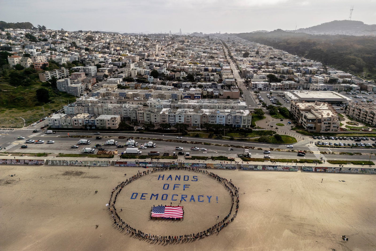 An einem Strand im Bundesstaat Kalifornien bildeten Demonstranten einen menschlichen Kreis um eine US-Flagge und den Slogan «Hände weg von der Demokratie!». 