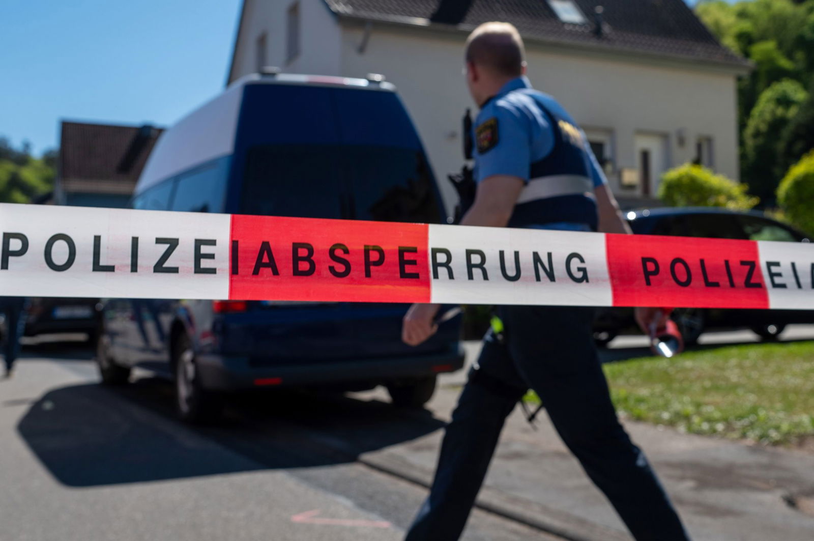 Ein Polizist geht an einem Absperrband eines Tatorts vorbei. 