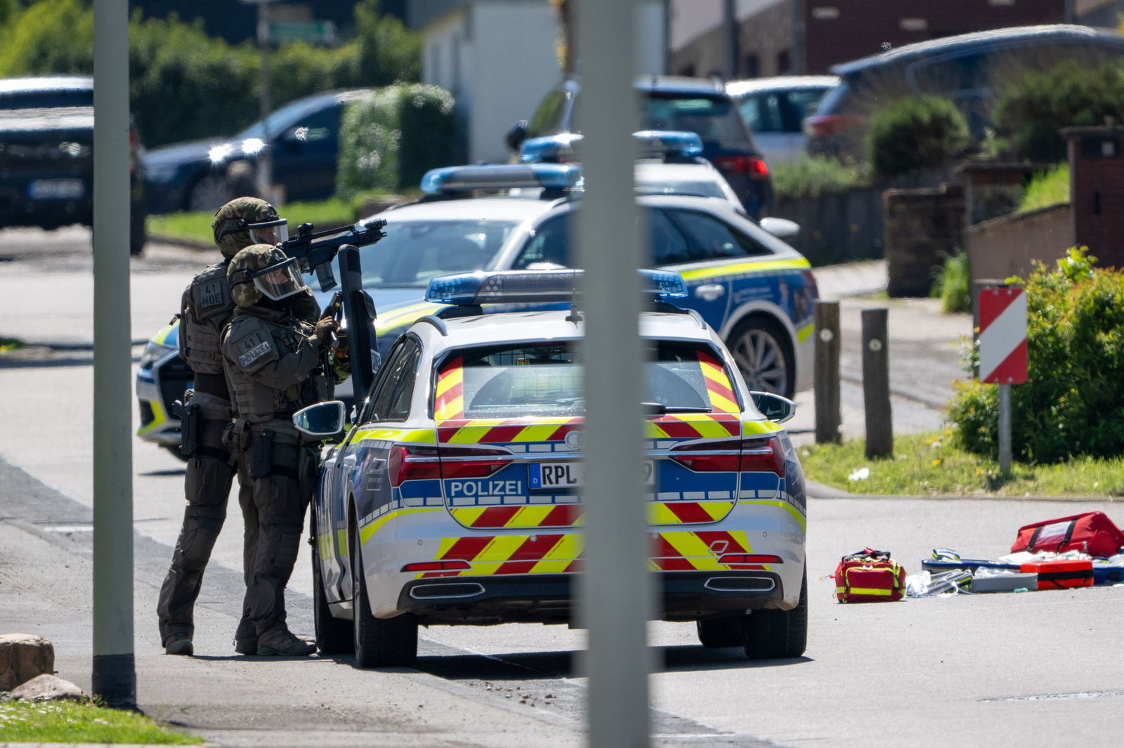 Mitglieder eines SEK, Feuerwehr und ein Notarzt sind an einem Haus im Einsatz.
