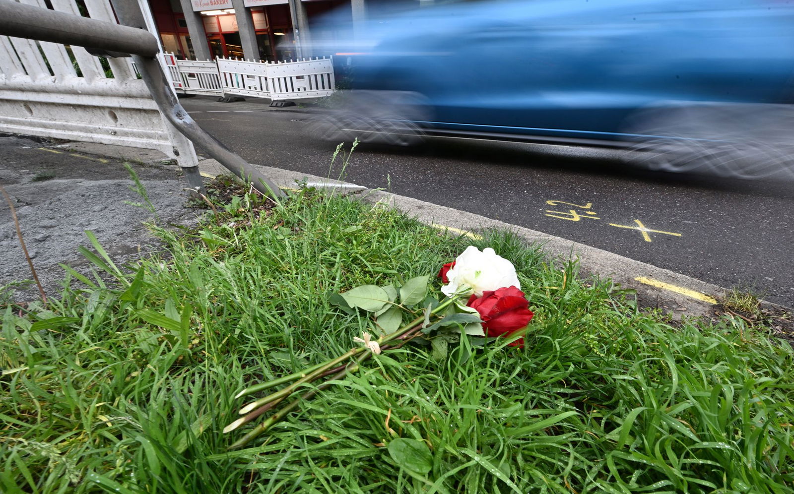 Am Tag nach dem Unfall liegen Rosen am Straßenrand. 