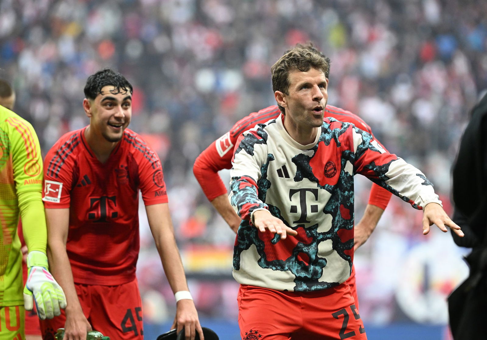 Thomas Müller (r) feiert vor der Bayern-Kurve in Leipzig. 