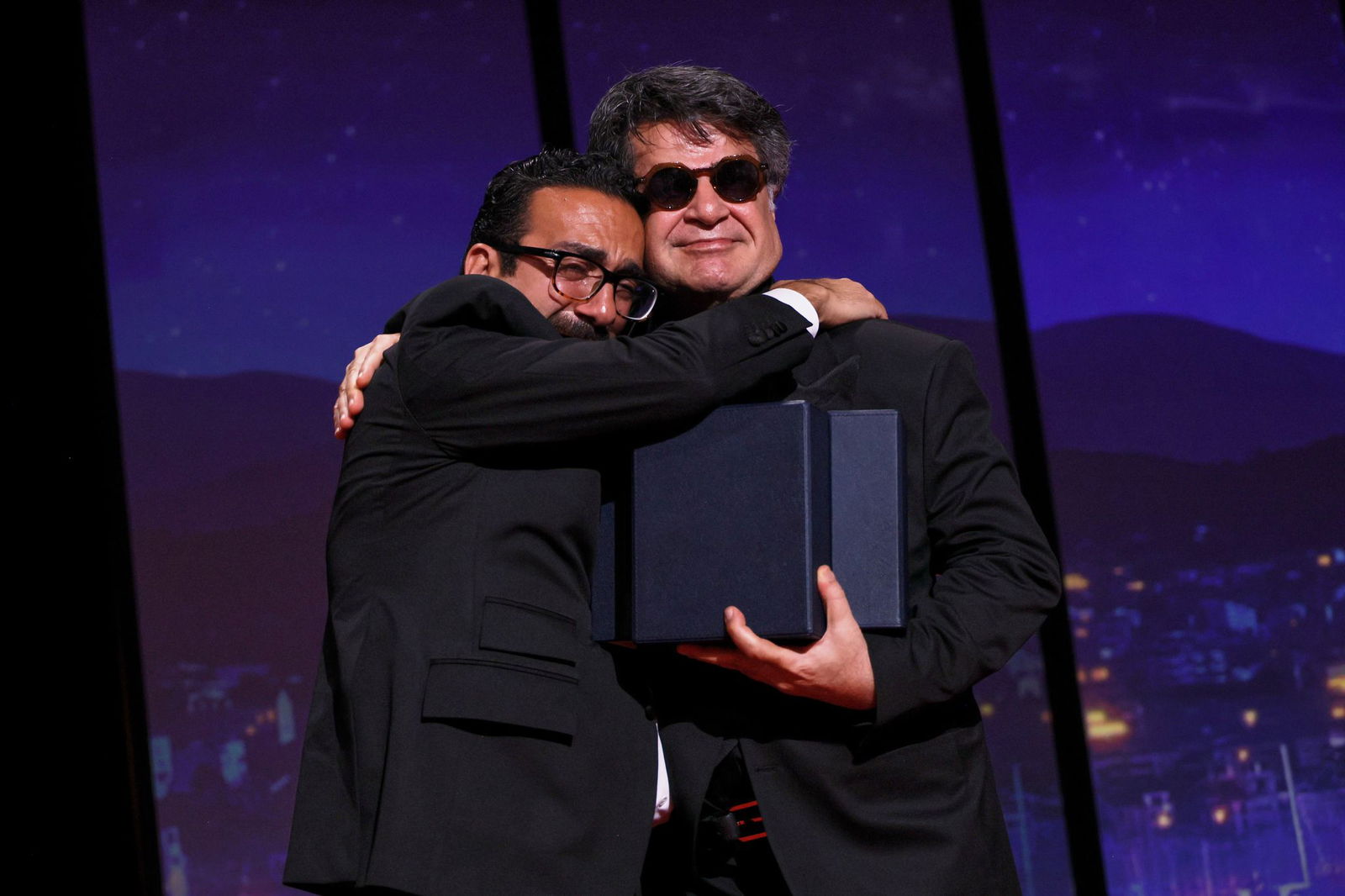Der Filmemacher Vahid Mobseri umarmt Jafar Panahi bei der Preisverleihung.