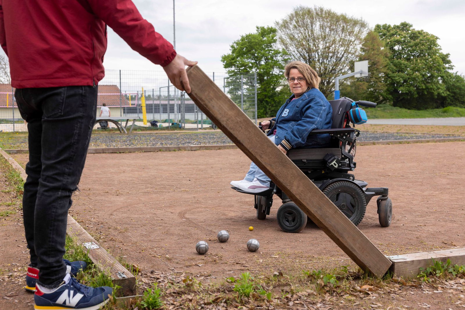Auf dem umgebauten Sportplatz in Sörgenloch kann auch Rollstuhlnutzerin Gracia Schade Boule spielen. 