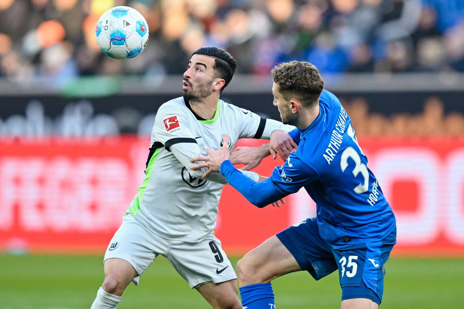 Wolfsburgs Mohamed Amoura (l) und Hoffenheims Arthur Chaves im Zweikampf.