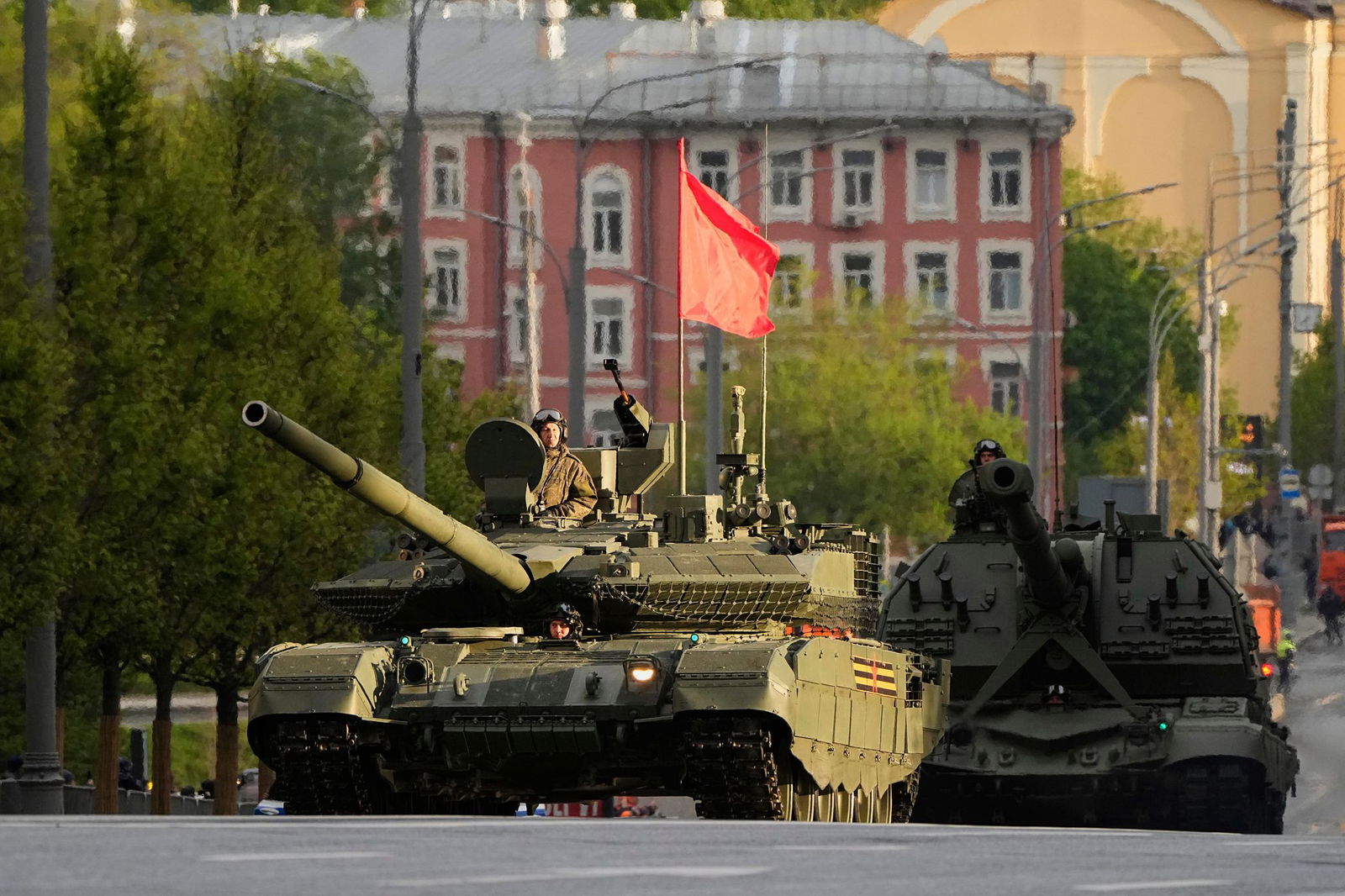 Ein russischer Panzer und eine Panzerhaubitze rollen auf einer Straße in Richtung Roter Platz, um an einer Probe für die Militärparade zum Tag des Sieges  teilzunehmen.