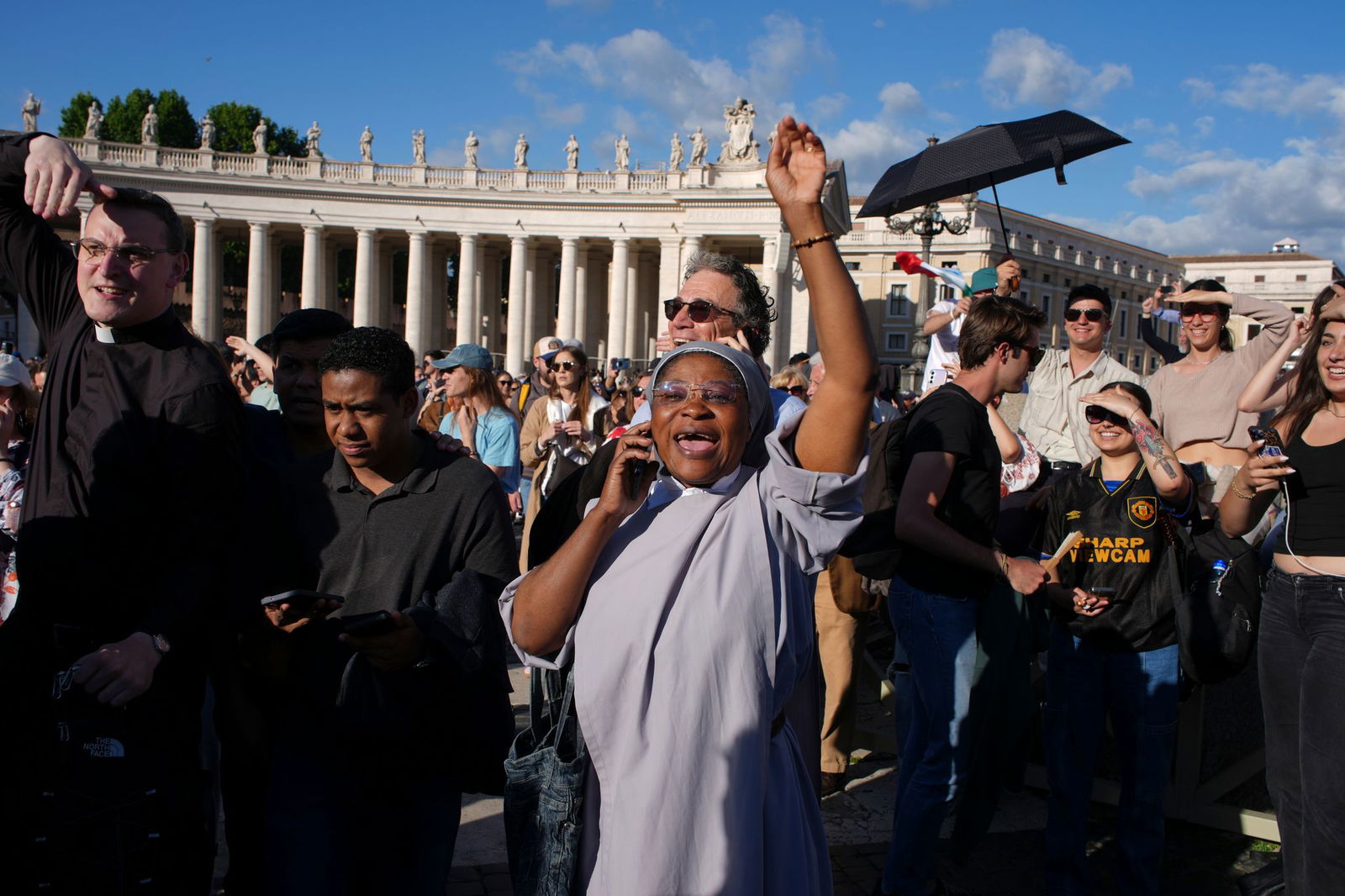 Gläubige telefonieren mit ihren Angehörigen, um vom neuen Papst zu berichten.